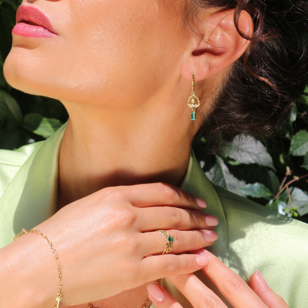 The dark haired model is wearing emerald earrings chviruli by Marilisi jewelry House