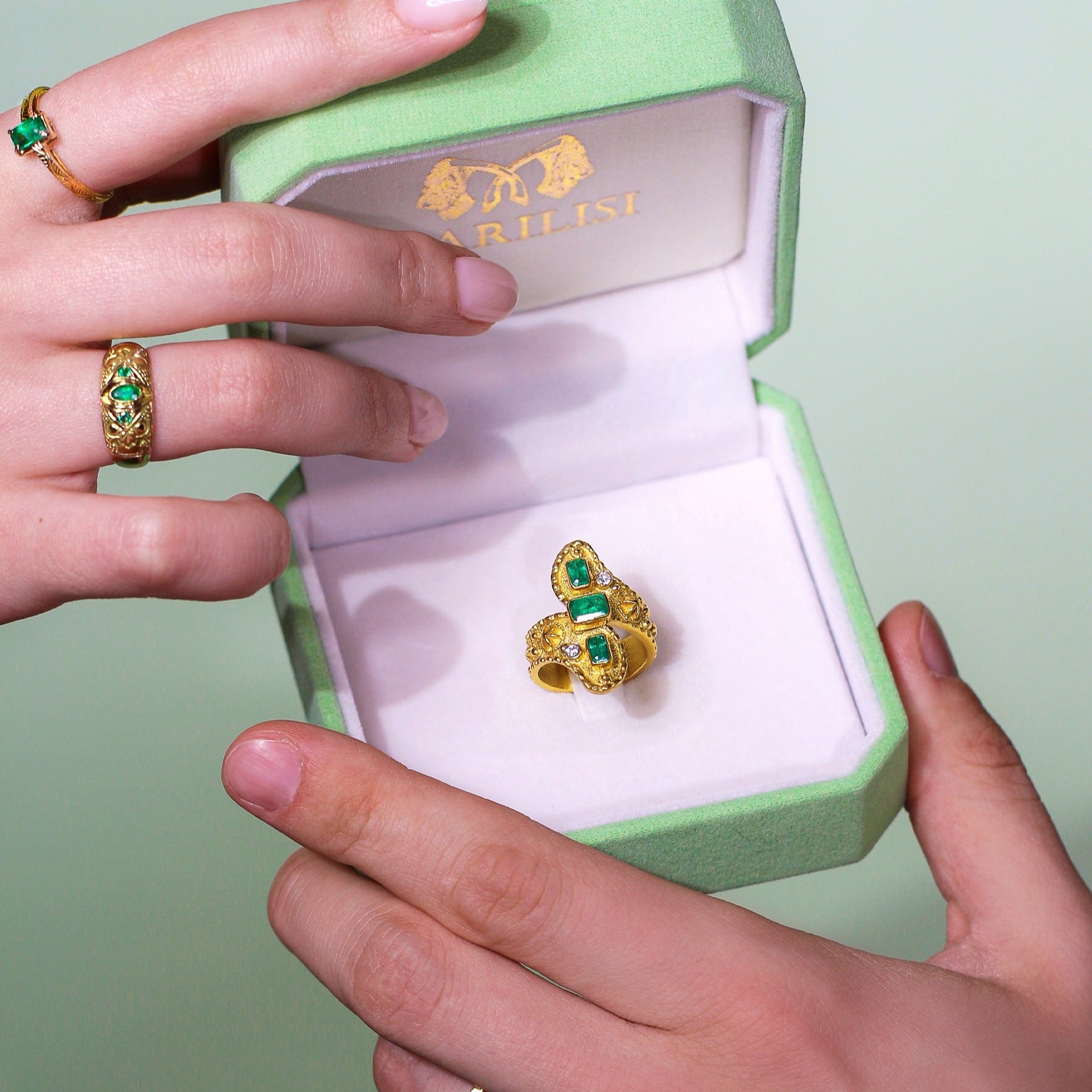 Marilisi Gold and Emerald ring damasco in gift box held by womand and a man