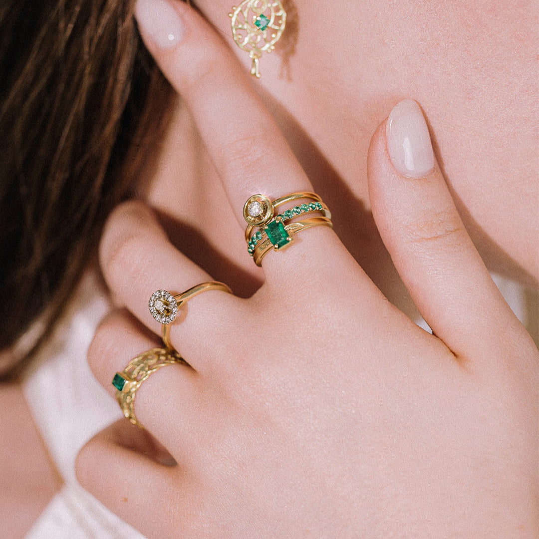 Model wearing collection of gold diamond and emerald rings from Marilisi 