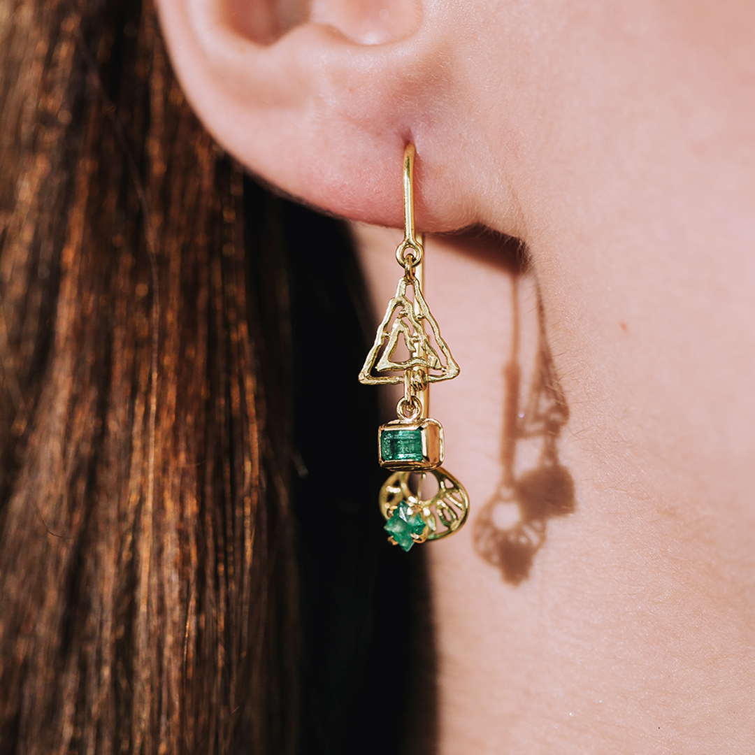 Model wearing gold and emerald unique designer jewelry earrings by marilisi