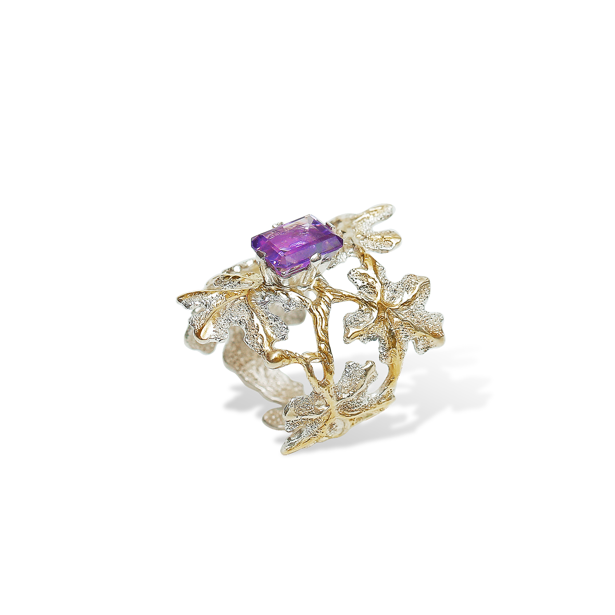 Gold and silver ring with a purple gemstone on a white background