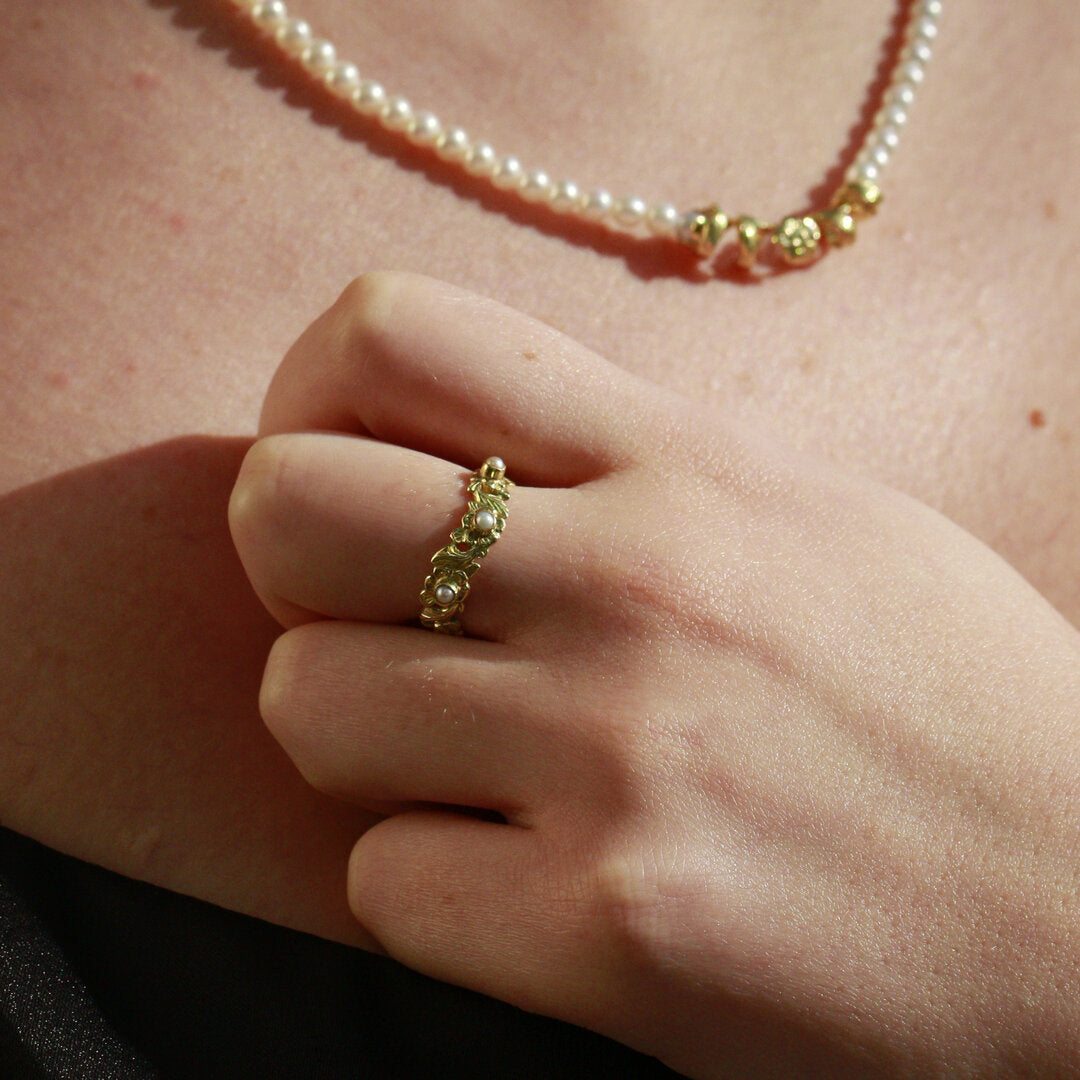 Beautiful floral ring with pearls on model's hand